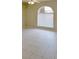 A bedroom with a large window, ceiling fan and neutral tile floor offers bright natural light at 7506 W Devonshire Ave, Phoenix, AZ 85033