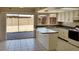 Bright kitchen featuring white cabinets, granite countertops, tile flooring, and sliding door to backyard at 7506 W Devonshire Ave, Phoenix, AZ 85033