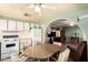The kitchen and dining area feature white cabinetry, laminate floors, and modern appliances in this mobile home at 7807 E Main St # Cc105, Mesa, AZ 85207