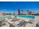 A community pool with lounge chairs, umbrellas, and palm trees on a sunny day at 7807 E Main St # Cc105, Mesa, AZ 85207