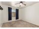 Carpeted bedroom featuring a ceiling fan, window with blinds and dark curtains, and soft neutral walls at 826 W Devon Dr, Gilbert, AZ 85233