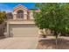 Two-story home with a beige stucco exterior, red tile roof, and a large two-car garage offering classic architectural style at 826 W Devon Dr, Gilbert, AZ 85233