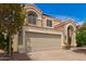 Two-story home with a beige stucco exterior, red tile roof, and a large two-car garage with a classic architectural style at 826 W Devon Dr, Gilbert, AZ 85233