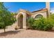 Beige stucco home with a red tile roof, arched entryway, and desert landscaping for a charming curb appeal at 826 W Devon Dr, Gilbert, AZ 85233