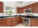 This kitchen features stainless steel appliances, wood cabinetry, and a beautiful window view at 826 W Devon Dr, Gilbert, AZ 85233