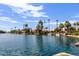 Scenic lake view showcasing waterfront homes and palm trees under a clear blue sky at 826 W Devon Dr, Gilbert, AZ 85233