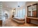Bright, spacious bathroom with a large tub, travertine floors, and glass block accents at 8392 E Eagle Feather Rd, Scottsdale, AZ 85266