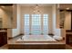 Bathroom featuring a large soaking tub with travertine surround, glass block accents and pendant lighting at 8392 E Eagle Feather Rd, Scottsdale, AZ 85266