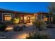Charming home with a well-lit front entrance, desert landscaping, and stone accents at 8392 E Eagle Feather Rd, Scottsdale, AZ 85266