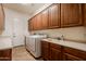 Well-equipped laundry room featuring a washer, dryer, sink, and plenty of cabinet space at 8392 E Eagle Feather Rd, Scottsdale, AZ 85266
