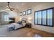 This main bedroom features a fireplace, ceiling fan, and plantation shutters for added privacy at 8392 E Eagle Feather Rd, Scottsdale, AZ 85266