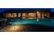 A luxurious backyard pool and patio area illuminated at twilight at 8392 E Eagle Feather Rd, Scottsdale, AZ 85266
