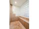 Tiled walk-in shower featuring glass block and a built-in bench at 8392 E Eagle Feather Rd, Scottsdale, AZ 85266