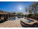 Backyard pool area with a stone patio, lush landscaping, and clear blue skies at 8392 E Eagle Feather Rd, Scottsdale, AZ 85266
