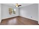 This unfurnished bedroom has hardwood flooring, a ceiling fan and a large window at 8787 E Mountain View Rd # 1087, Scottsdale, AZ 85258