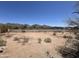 Large lot with desert landscape, partial fencing, and views of the mountains in the distance at 9267 E Rimrock Dr, Scottsdale, AZ 85255