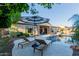 Serene backyard showcasing a sparkling pool, sun loungers, and a covered patio with comfortable seating at 9369 W Via Montoya Dr, Peoria, AZ 85383