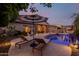 Inviting backyard at dusk features a sparkling pool, patio and lounge seating at 9369 W Via Montoya Dr, Peoria, AZ 85383