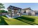 Lush backyard features a pergola with seating, a built-in grill, and an immaculate green lawn at 9369 W Via Montoya Dr, Peoria, AZ 85383
