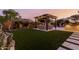 Manicured backyard featuring an outdoor kitchen, pergola, and well-maintained artificial turf at 9369 W Via Montoya Dr, Peoria, AZ 85383