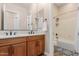 A bathroom featuring dual sinks, wood cabinets, and a shower-tub combo at 9369 W Via Montoya Dr, Peoria, AZ 85383