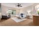 Bright main bedroom with a ceiling fan, seating area, large window and ensuite bathroom access at 9369 W Via Montoya Dr, Peoria, AZ 85383