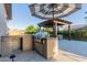 Outdoor kitchen area with a built-in grill, counter space, and shaded seating under a pergola at 9369 W Via Montoya Dr, Peoria, AZ 85383