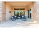 Stylish covered patio with comfortable seating, stone accents, and large windows for natural light at 9369 W Via Montoya Dr, Peoria, AZ 85383