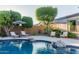 Inviting pool area with lounge chairs, umbrellas, and lush landscaping, perfect for relaxation at 9369 W Via Montoya Dr, Peoria, AZ 85383
