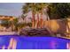 Luxurious backyard pool with stone waterfall and palm trees, creating a tropical oasis at 9369 W Via Montoya Dr, Peoria, AZ 85383