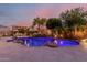 Tranquil backyard pool with rock waterfall feature surrounded by lush landscaping and a pergola at 9369 W Via Montoya Dr, Peoria, AZ 85383