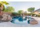 Sparkling pool with rock features, lush landscaping, and lounge chairs for relaxation at 9369 W Via Montoya Dr, Peoria, AZ 85383