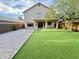 Attractive backyard with low-maintenance artificial grass, covered patio, and partial privacy fence at 10031 W Hess St, Tolleson, AZ 85353