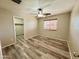 Inviting bedroom with a walk-in closet, ceiling fan, wood laminate flooring, and a window with blinds at 10031 W Hess St, Tolleson, AZ 85353