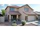 Charming two-story home with a well-manicured front yard and inviting front porch, stone accents, and tile roof at 10031 W Hess St, Tolleson, AZ 85353
