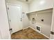 Functional laundry room featuring tile floor, washer and dryer hookups, and access to the exterior at 10031 W Hess St, Tolleson, AZ 85353
