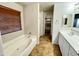 Beautiful bathroom showcasing a soaking tub, walk-in closet, and a single sink vanity with modern fixtures at 10031 W Hess St, Tolleson, AZ 85353