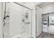 Modern bathroom with a glass-enclosed shower, white fixtures, and access to a walk-in closet at 11008 N 165Th Ave, Surprise, AZ 85388