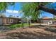 A beautifully landscaped backyard features a covered patio, built-in grill, and large trees, perfect for relaxation at 1106 W Glenrosa Ave, Phoenix, AZ 85013