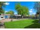 Expansive backyard featuring a lush lawn, mature trees, and a built-in BBQ, perfect for outdoor entertaining at 1106 W Glenrosa Ave, Phoenix, AZ 85013