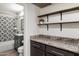 Bathroom featuring dark wood shelves and cabinet with a light granite countertop at 1106 W Glenrosa Ave, Phoenix, AZ 85013