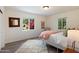 Sunlit bedroom with light wood floors, fluffy rug, and views of the manicured yard at 1106 W Glenrosa Ave, Phoenix, AZ 85013