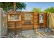 Exterior shot of the Woodlea Melrose Tool Shed, featuring a rustic shed, small library, and stone landscaping at 1106 W Glenrosa Ave, Phoenix, AZ 85013