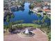Captivating aerial view of lakeside homes with lush palm trees, a fountain, and community space at 1114 W Windjammer Dr, Gilbert, AZ 85233