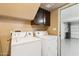 Efficient laundry room with a washer and dryer, accompanied by overhead cabinet storage for organizing laundry essentials at 1114 W Windjammer Dr, Gilbert, AZ 85233