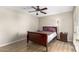 Bedroom with wood-look flooring, ceiling fan, and a dark wood sleigh bed and nightstand at 1217 N Miller Rd # 32, Scottsdale, AZ 85257