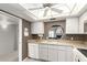 Bright kitchen features white cabinetry, a cozy pass-through window, and laminate countertops at 1217 N Miller Rd # 32, Scottsdale, AZ 85257