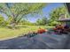 Expansive backyard featuring mature trees, lush green grass, tractor, and an outbuilding at 125 N Fraser E Dr, Mesa, AZ 85203