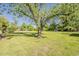 A large mature tree stands prominently in the manicured green lawn in the backyard at 125 N Fraser E Dr, Mesa, AZ 85203