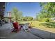 Backyard patio with a firepit and outdoor chairs on a large grassy lawn at 125 N Fraser E Dr, Mesa, AZ 85203